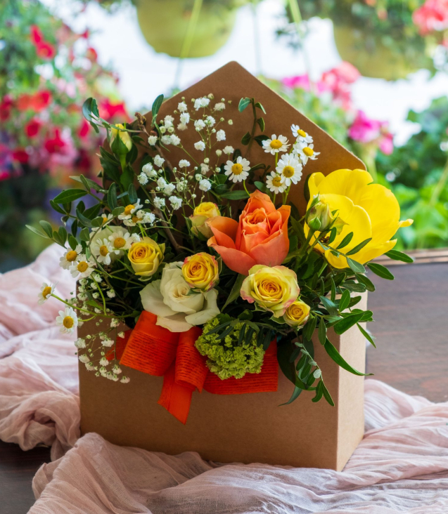 scatola a forma di lettera con composizione floreale