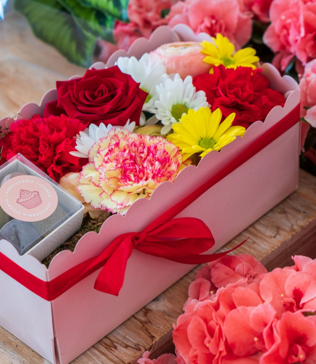composizione in spugna di fiori freschi e cioccolatini in scatola rosa con coperchio trasparente