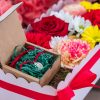 composizione in spugna di fiori freschi e gioiello in argento in scatola rosa con coperchio trasparente
