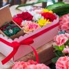 composizione in spugna di fiori freschi e gioiello in argento in scatola rosa con coperchio trasparente