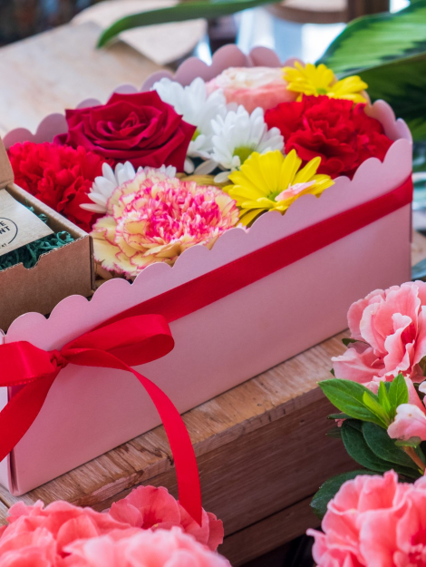 composizione in spugna di fiori freschi e gioiello in argento in scatola rosa con coperchio trasparente