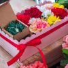 composizione in spugna di fiori freschi e gioiello in argento in scatola rosa con coperchio trasparente