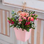 borsina rosa con manici dorati di metallo con dentro composizione floreale per la festa della mamma