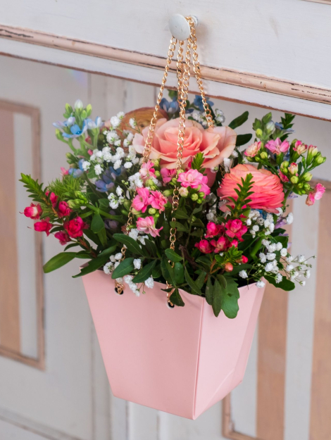 borsina rosa con manici dorati di metallo con dentro composizione floreale per la festa della mamma