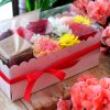 composizione in spugna di fiori freschi e gioiello in argento in scatola rosa con coperchio trasparente