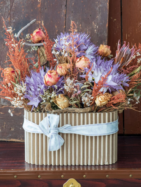 contenitore di cartone con composizione di fiori secchi colorati