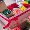 composizione in spugna di fiori freschi e gioiello in argento in scatola rosa con coperchio trasparente